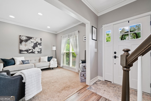 foyer with light wood finished floors, crown molding, recessed lighting, and baseboards