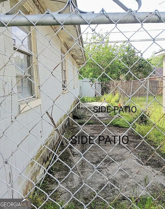 view of side of home featuring fence