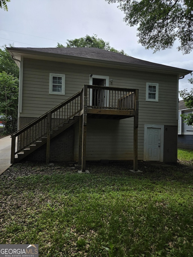 rear view of property with stairway, a lawn, and a wooden deck