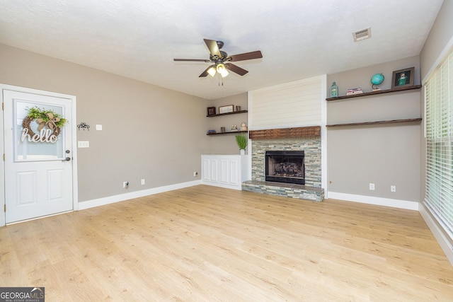 10 Queens Ct, Sharpsburg, GA 30277 - unfurnished living room featuring light wood finished floors, a ceiling fan, and a stone fireplace