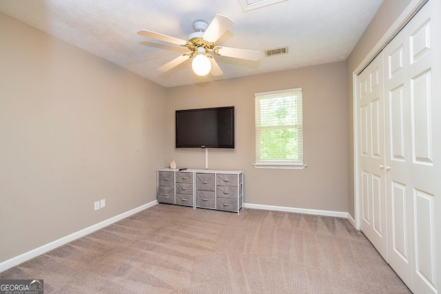 10 Queens Ct, Sharpsburg, GA 30277 - unfurnished bedroom featuring light colored carpet, a closet, a ceiling fan, and a textured ceiling