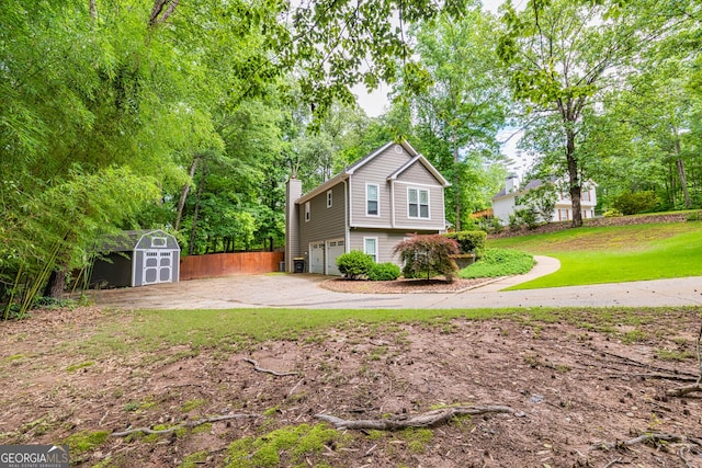 10 Queens Ct, Sharpsburg, GA 30277 - view of front of property featuring a shed, a garage, a chimney, driveway, and a front lawn