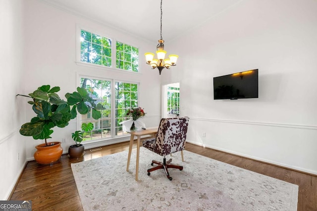 office space with a chandelier, baseboards, crown molding, and wood finished floors