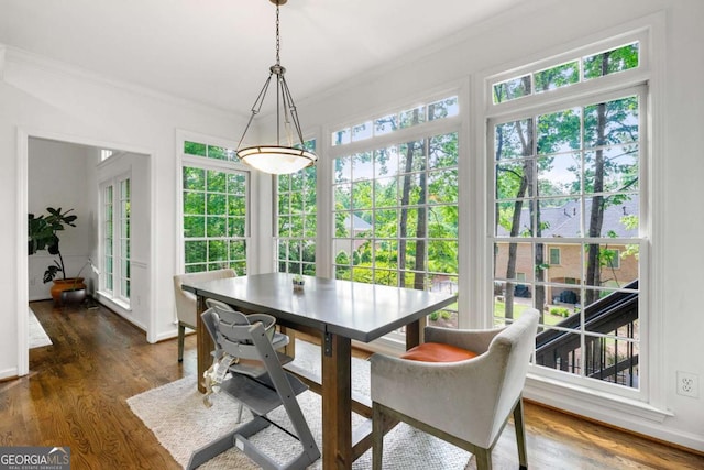 dining space with crown molding, dark wood-style floors, and baseboards
