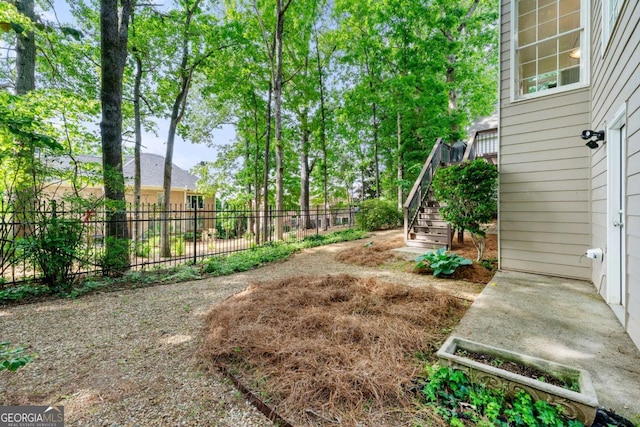 view of yard with fence and stairs