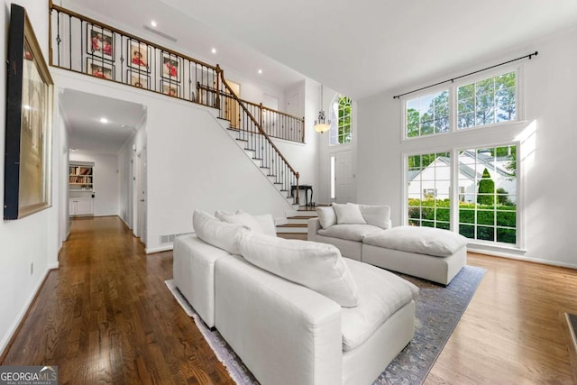 living area featuring stairway, wood finished floors, baseboards, and recessed lighting