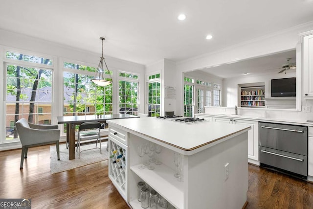 kitchen with ornamental molding, light countertops, stainless steel dishwasher, a kitchen island, and white cabinetry