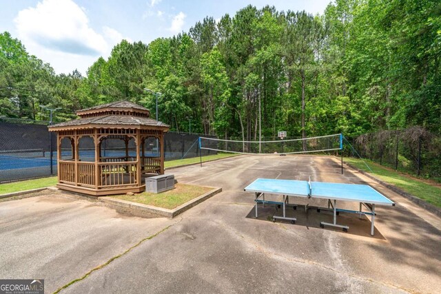 surrounding community featuring a gazebo, fence, a forest view, and a tennis court