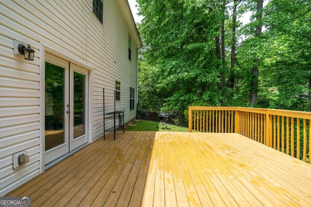 wooden terrace featuring french doors and view of scattered trees