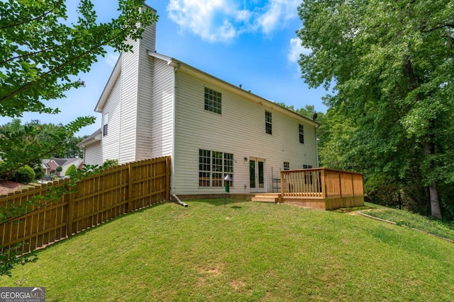 back of property with a chimney and a wooden deck