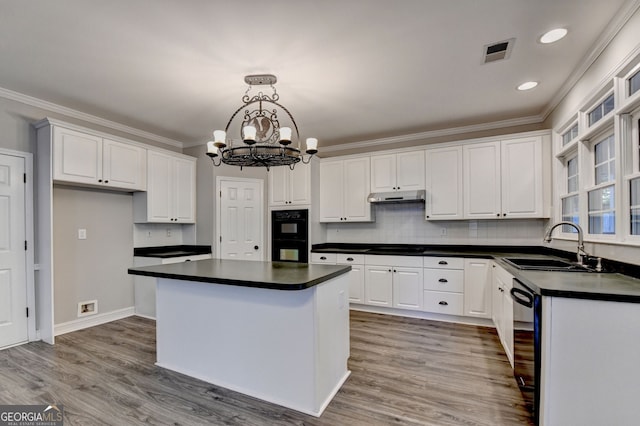 2049 Mclain Rd NW, Acworth, GA 30101 - kitchen featuring a sink, dark countertops, under cabinet range hood, a chandelier, and ornamental molding