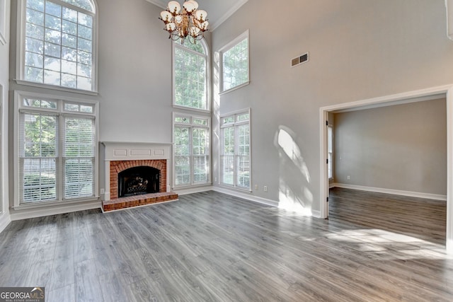2049 Mclain Rd NW, Acworth, GA 30101 - unfurnished living room featuring a high ceiling, baseboards, a chandelier, wood finished floors, and ornamental molding