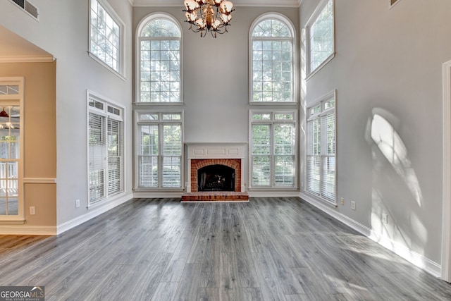 2049 Mclain Rd NW, Acworth, GA 30101 - unfurnished living room featuring crown molding, baseboards, healthy amount of natural light, a fireplace, and a towering ceiling