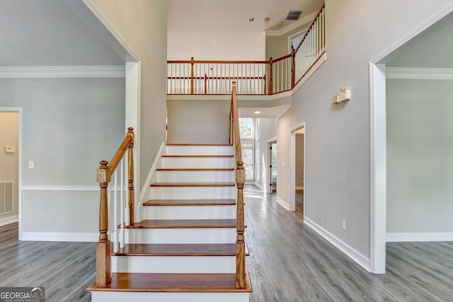 2049 Mclain Rd NW, Acworth, GA 30101 - stairway featuring wood finished floors, ornamental molding, baseboards, and a high ceiling
