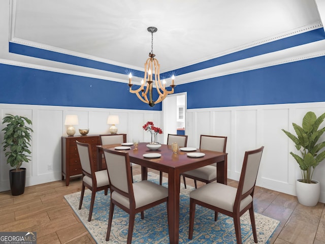 230 Shorewood Ct, Mcdonough, GA 30252 - dining space with a decorative wall, a chandelier, a wainscoted wall, wood finished floors, and a tray ceiling