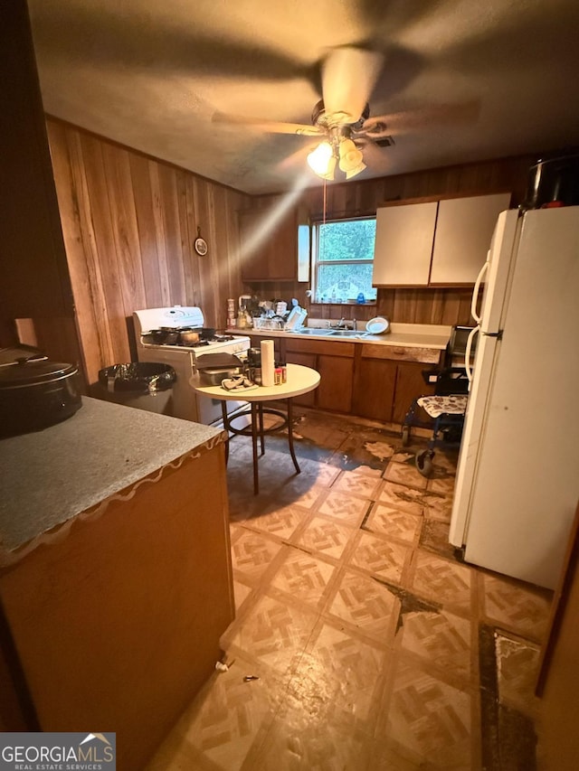3448 Orchard Cir, Decatur, GA 30032 - kitchen with white appliances, wooden walls, light floors, a ceiling fan, and an office area