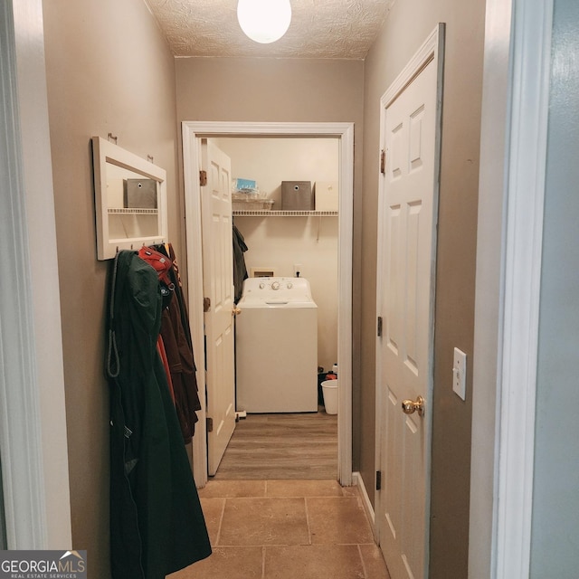 washroom with washer / clothes dryer and a textured ceiling