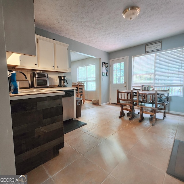 kitchen featuring baseboards, white cabinets, a textured ceiling, light countertops, and light tile patterned floors