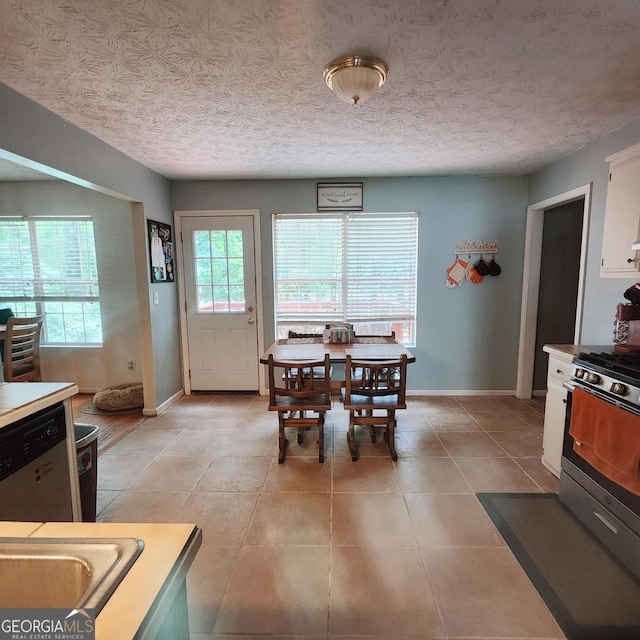 dining area with baseboards, light tile patterned floors, and a textured ceiling