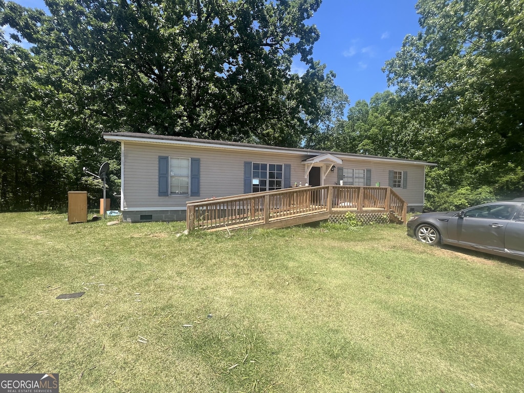 manufactured / mobile home with crawl space, a wooden deck, and a front lawn