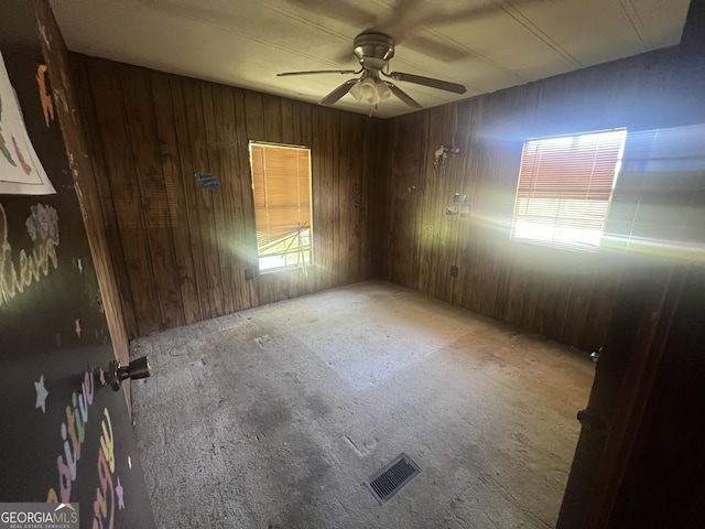 491 Cavender Creek Rd, Carrollton, GA 30116 - empty room featuring ceiling fan, wood walls, and carpet floors
