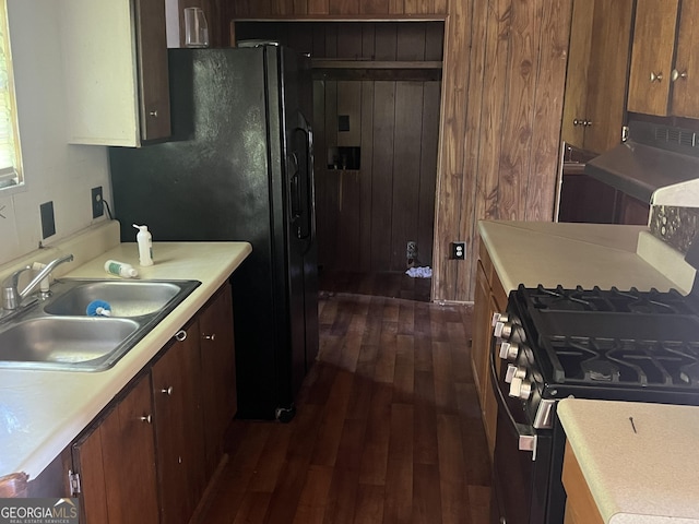 491 Cavender Creek Rd, Carrollton, GA 30116 - kitchen with a sink, range with gas cooktop, dark wood finished floors, light countertops, and wood walls