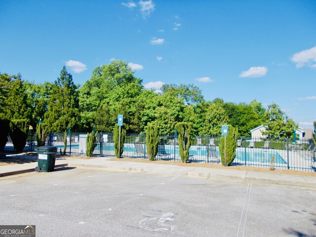 1720 Grant Ct, Braselton, GA 30517 - surrounding community with fence, a swimming pool, and uncovered parking