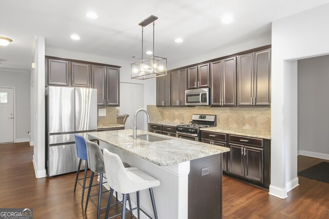 1720 Grant Ct, Braselton, GA 30517 - kitchen with appliances with stainless steel finishes, a sink, dark brown cabinets, dark wood-type flooring, and light stone counters