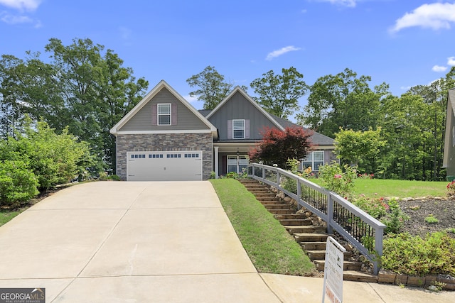 114 Brookstone Dr, Carrollton, GA 30116 - view of front of home featuring a garage, concrete driveway, stone siding, board and batten siding, and a front yard