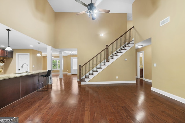 114 Brookstone Dr, Carrollton, GA 30116 - living room with a towering ceiling, a ceiling fan, dark wood finished floors, baseboards, and stairway