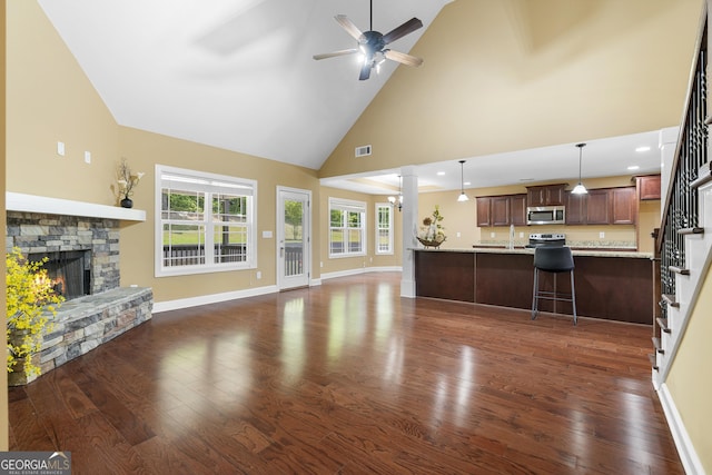 114 Brookstone Dr, Carrollton, GA 30116 - unfurnished living room featuring ceiling fan, high vaulted ceiling, dark wood-style floors, stairs, and a stone fireplace