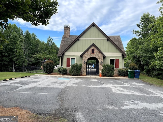 114 Brookstone Dr, Carrollton, GA 30116 - view of front of property featuring board and batten siding, stone siding, a chimney, fence, and uncovered parking