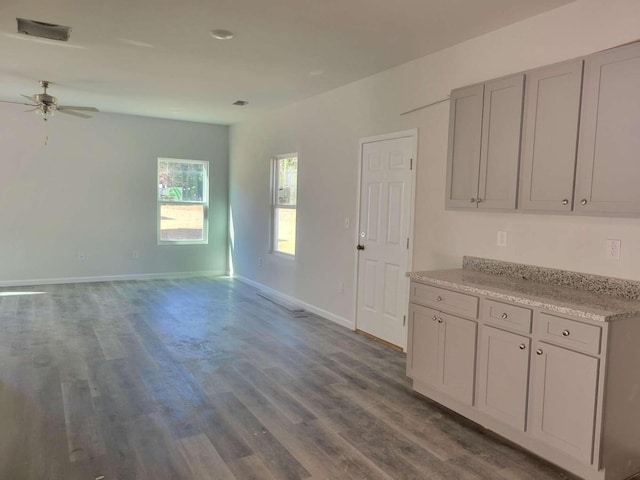 kitchen featuring ceiling fan, dark wood finished floors, baseboards, and gray cabinetry