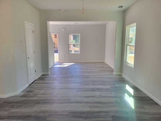 spare room with plenty of natural light, wood finished floors, and baseboards