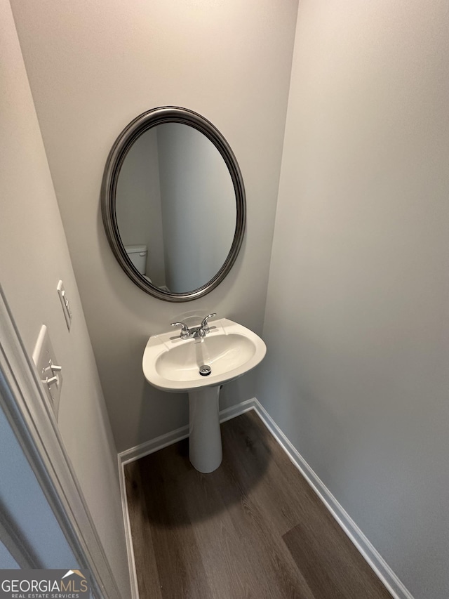 bathroom with wood finished floors and baseboards