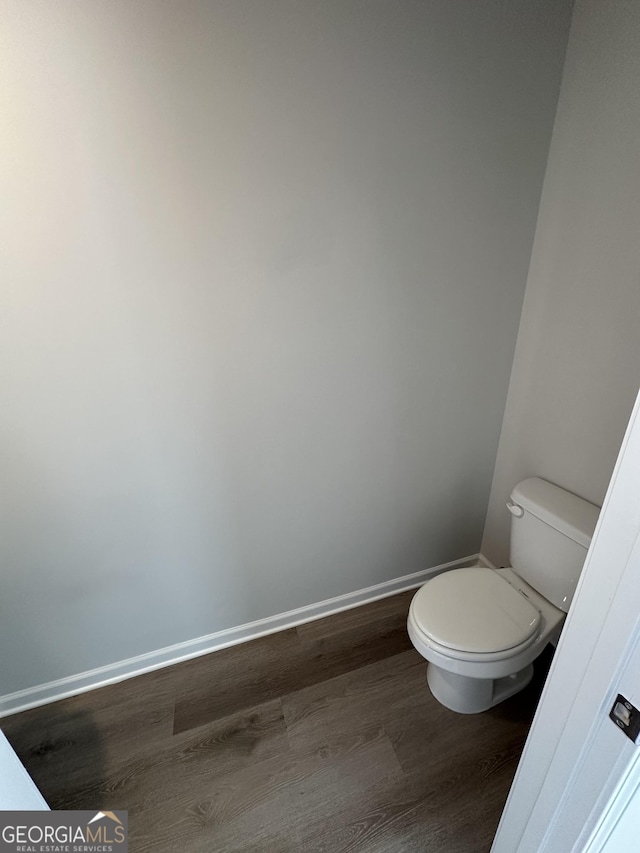 bathroom featuring wood finished floors, toilet, and baseboards