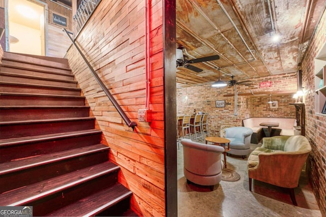 527 Main St, Suwanee, GA 30024 - stairway with brick wall, a ceiling fan, and concrete floors