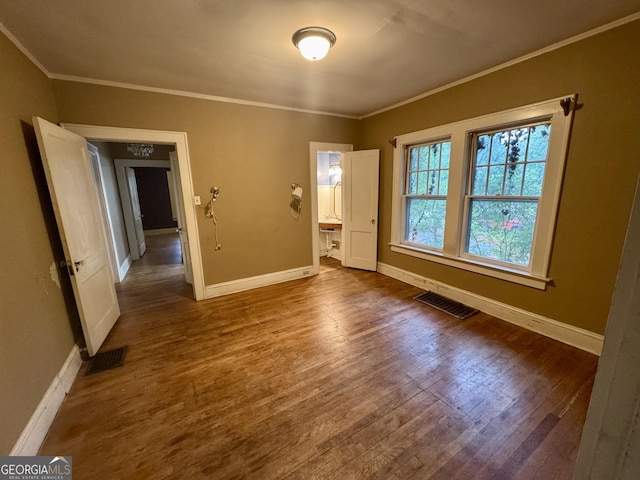 empty room with baseboards, dark wood-type flooring, and crown molding