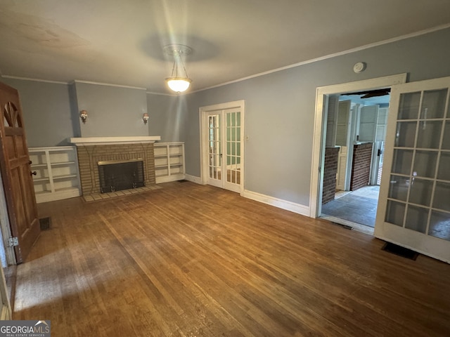 unfurnished living room with ornamental molding, wood finished floors, a brick fireplace, and baseboards