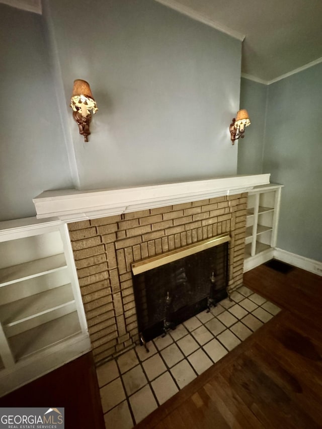 detailed view of a fireplace, ornamental molding, wood finished floors, and baseboards