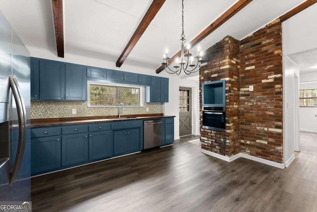 kitchen with stainless steel appliances, blue cabinetry, a sink, and decorative backsplash