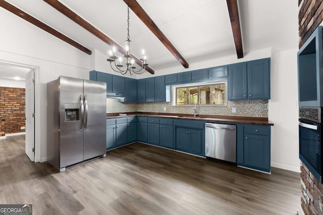 kitchen with appliances with stainless steel finishes, blue cabinets, a sink, and a chandelier