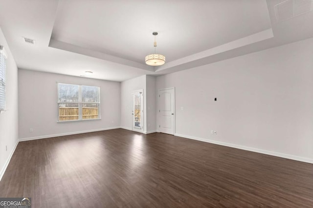 7995 Brewton Creek Dr, Cumming, GA 30028 - spare room with a tray ceiling, dark wood-style flooring, and baseboards