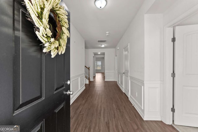 7995 Brewton Creek Dr, Cumming, GA 30028 - hall with dark wood finished floors, a wainscoted wall, and a decorative wall