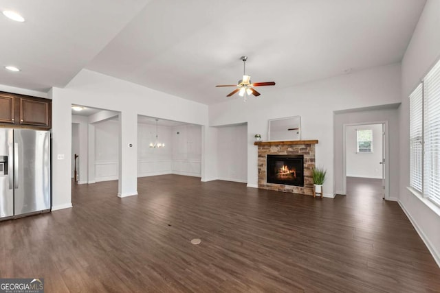 7995 Brewton Creek Dr, Cumming, GA 30028 - unfurnished living room featuring ceiling fan, dark wood-style flooring, a fireplace, a chandelier, and baseboards
