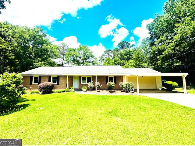 single story home featuring an attached carport, concrete driveway, a front yard, and an attached garage