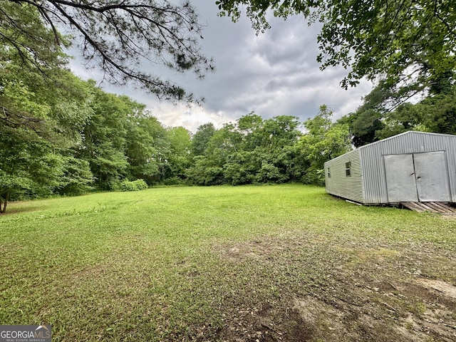 view of green lawn featuring an outbuilding and a storage shed