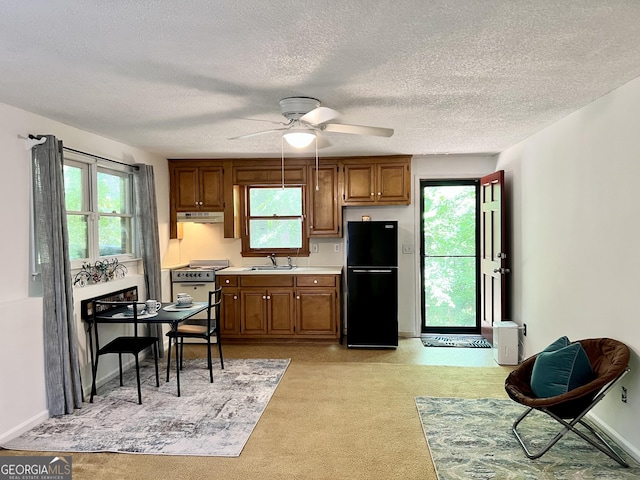 1461 Fox Forest Ter SW, Lilburn, GA 30047 - kitchen with freestanding refrigerator, white range with gas stovetop, a sink, light countertops, and a ceiling fan