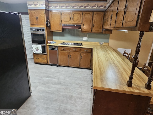 3978 Wc Hodges Rd, Statesboro, GA 30461 - kitchen with appliances with stainless steel finishes, under cabinet range hood, brown cabinetry, and wooden counters