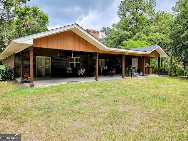 3978 Wc Hodges Rd, Statesboro, GA 30461 - rear view of house with a chimney, french doors, a yard, and a patio